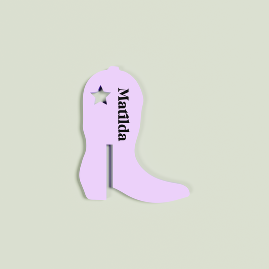 Purple cowboy boot-shaped drink tag with 'Matilda' on a light green background