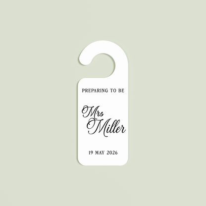 White Promesse door hanger with 'Preparing to be Mrs Miller 19 May 2026' black text | Saint Sauvant Auckland NZ