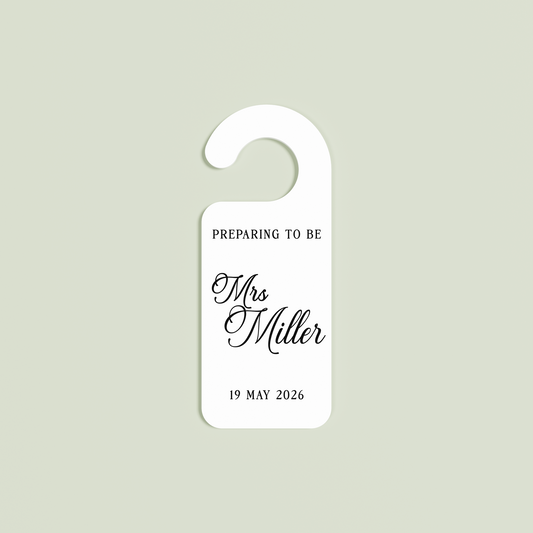 White Promesse door hanger with 'Preparing to be Mrs Miller 19 May 2026' black text | Saint Sauvant Auckland NZ